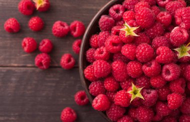 Kahverengi rustik ahşap arka plan üzerinde kırmızı taze frambuaz