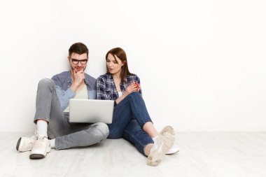 Boş odada dizüstü bilgisayar ile web sörf Çift