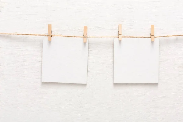 Tarjetas blancas en blanco en la cuerda, espacio de copia — Foto de Stock