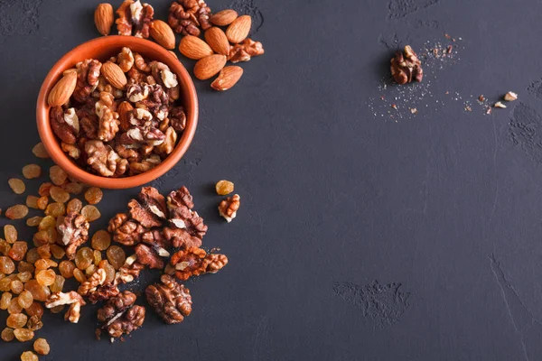 Nüsse und Rosinen vor schwarzem Hintergrund. gesunde Fettquelle für Veganer und Vegetarier — Stockfoto