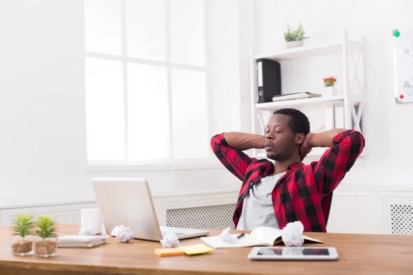 Cansado homem de negócios preto no escritório casual, olhando no laptop — Fotografia de Stock