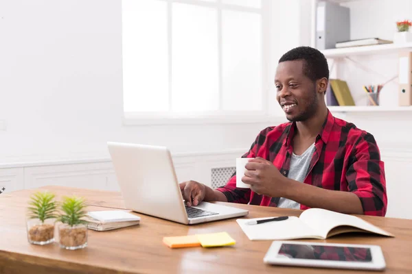 Gelukkig zwarte zakenman in casual kantoor, werken met een laptop — Stockfoto