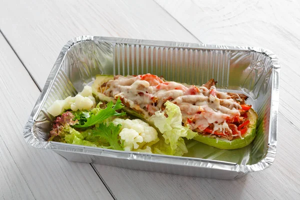 Restaurante comida tirar closeup em caixa de papel alumínio, abobrinha recheada — Fotografia de Stock