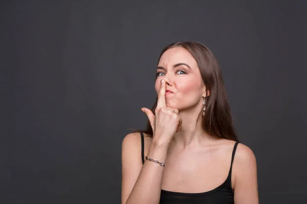 Jonge vrouw een grapje en haar neus aanraken — Stockfoto