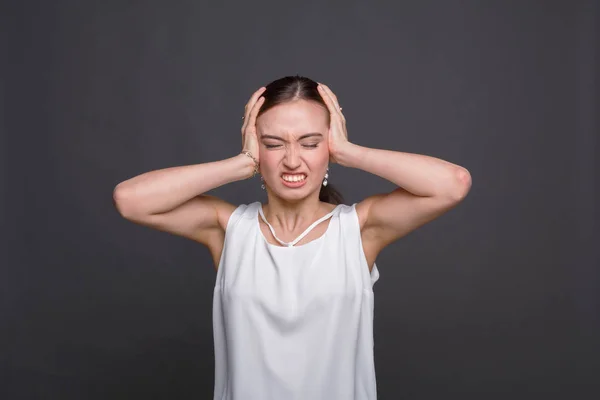 Retrato de una mujer enojada sosteniendo su cabeza — Foto de Stock