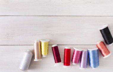 Renkli iplik biriktiricileri ahşap masa düz üzerinde yatıyordu