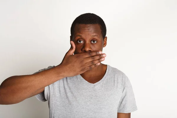 Nic neříkej koncept, černý muž pokrývající ústa rukou — Stock fotografie
