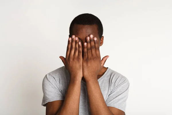 Hombre negro asustado cubriendo los ojos con las manos, no ve mal — Foto de Stock