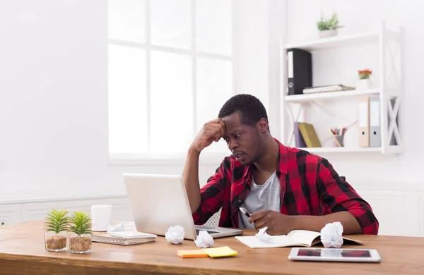 Doordachte zwarte zakenman in casual kantoor, werken met een laptop — Stockfoto