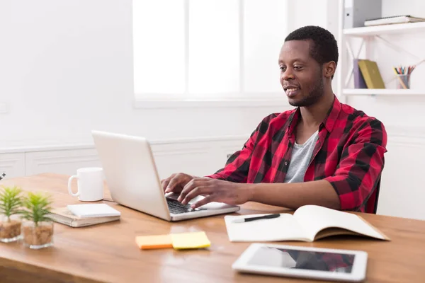 Gelukkig zwarte zakenman in casual kantoor, werken met een laptop — Stockfoto