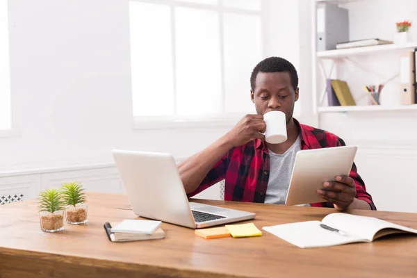 Geçici ofis, siyah işadamı kahve içme tablet, haber okuma — Stok fotoğraf
