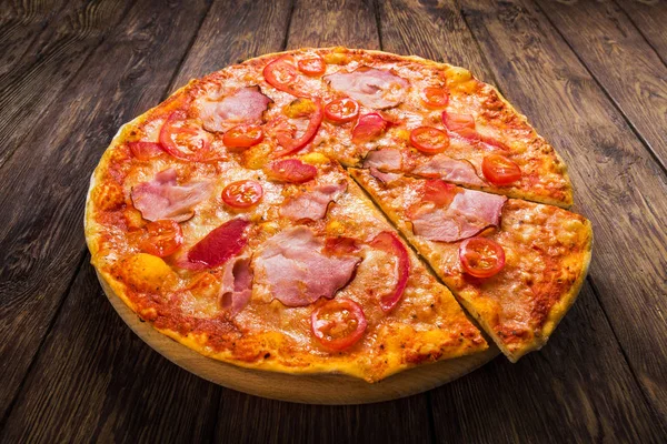 Delicious pizza with ham on wood — Stock Photo, Image