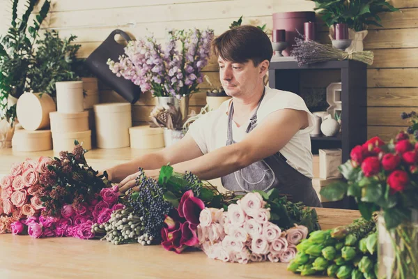 Assistente homem na entrega loja de flores fazer buquês — Fotografia de Stock
