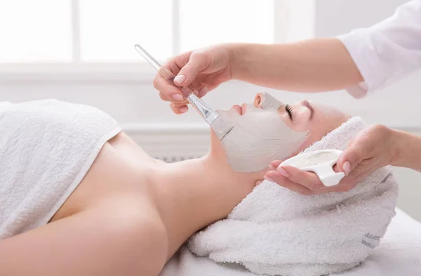 Mulher recebe máscara facial por esteticista no spa — Fotografia de Stock