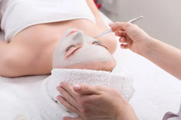 Frau bekommt Gesichtsmaske von Kosmetikerin im Spa — Stockfoto