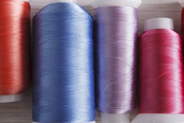 Renkli iplik biriktiricileri ahşap masa üzerinde kapat