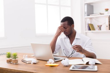 Office, yorgun Afro-Amerikan çalışan dizüstü bilgisayar ile çalışmak
