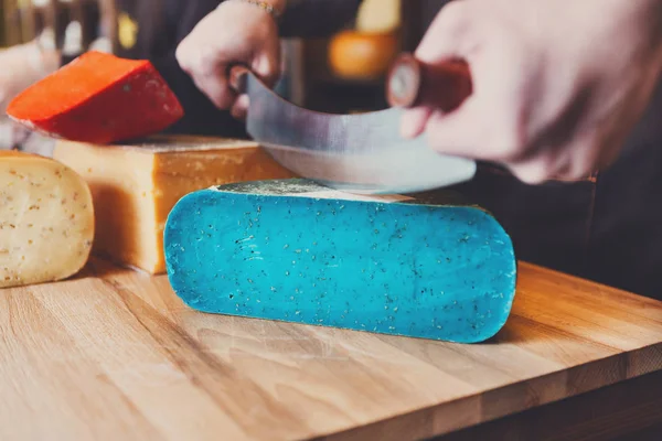 Резка гауды песто голубой сыр в продуктовом магазине — стоковое фото
