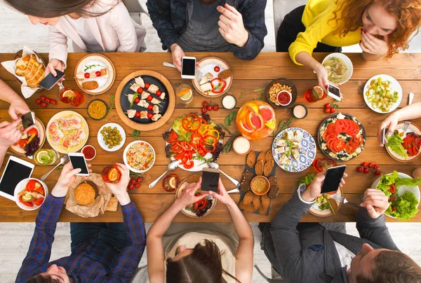 Gadget apparaat verslaving, vrienden diner met smarphones — Stockfoto