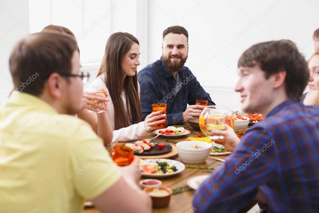 Group of happy people at festive table dinner party