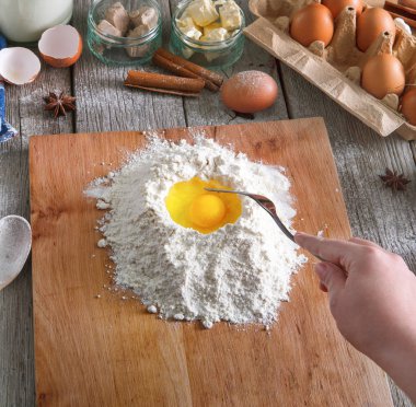 Kadın baker yumurta, tereyağı ve un ile hamur yapar
