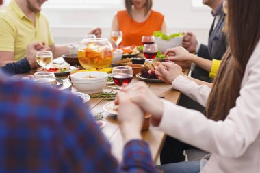 İnsanlar yemek masasında dua elele