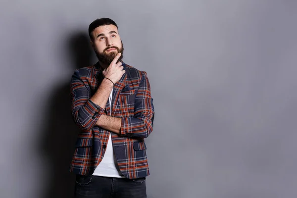 Nadenkend bebaarde hipster op zoek naar boven — Stockfoto