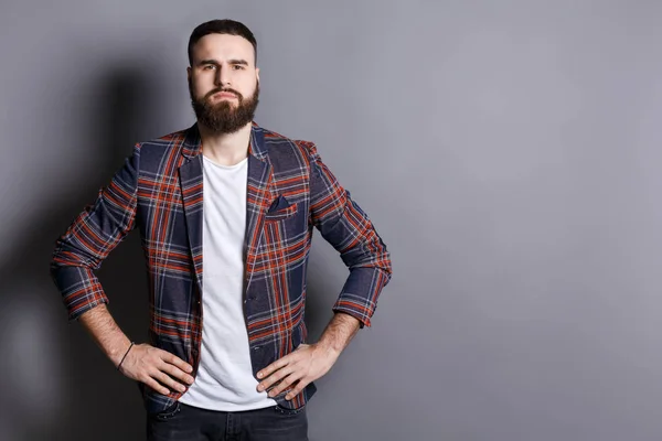 Hombre barbudo serio posando con las manos en las caderas — Foto de Stock