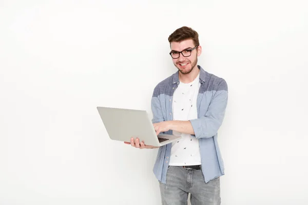 Hombre joven de pie con el ordenador portátil — Foto de Stock