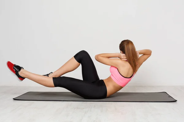 Figurka leżącej kobiety fitness robi crunches — Zdjęcie stockowe