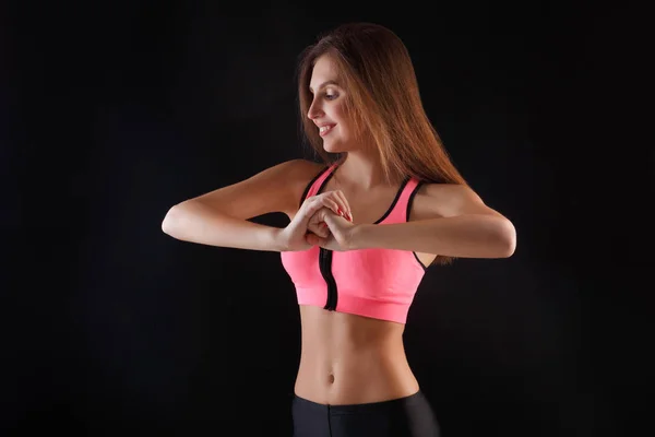 Schöne Fitness-Mädchen posiert auf schwarzem Hintergrund — Stockfoto