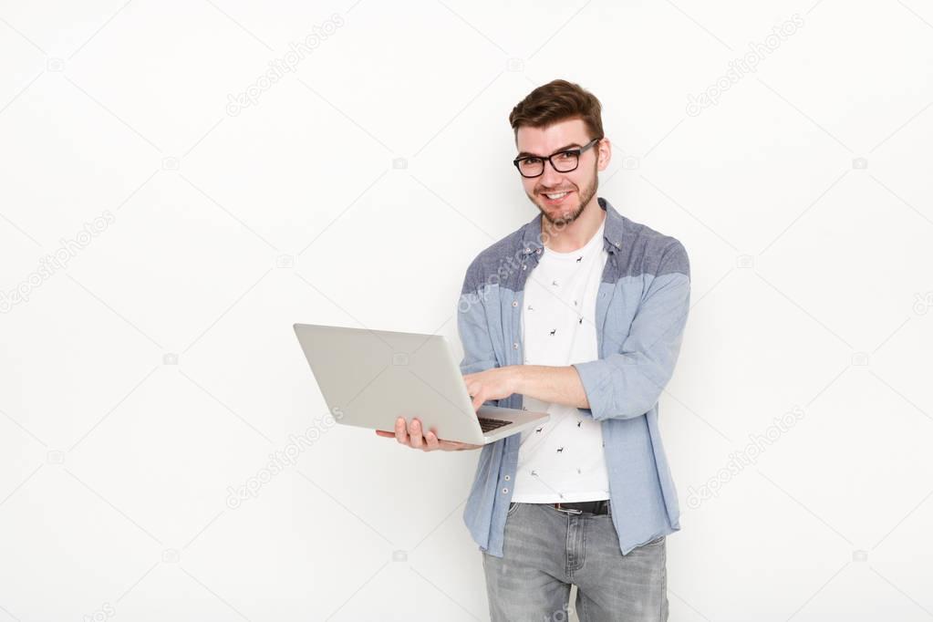 Young man standing with laptop