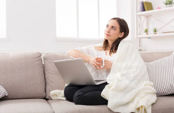 Ζεστό, άνετο σπίτι. Κορίτσι με ένα καρό με ένα φορητό υπολογιστή και ένα φλιτζάνι — Φωτογραφία Αρχείου