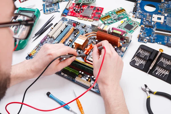 Ingeniero de chequeo placa base con multímetro — Foto de Stock