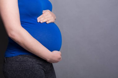 Onun göbek yan görünüm sevecen Pegnant kadın