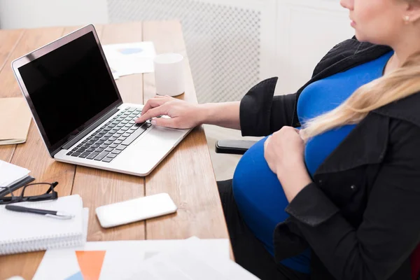 Mujer embarazada que trabaja en el ordenador portátil con pantalla en blanco — Foto de Stock