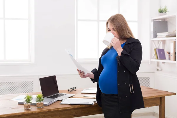 Беременная деловая женщина разговаривает по телефону с чашкой — стоковое фото