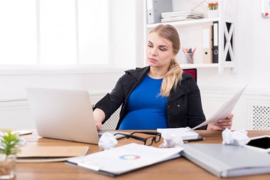 Hamile iş kadını işyerinde belgeleri okuma