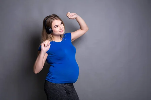 Pregnant woman listening music in headphones — Stock Photo, Image