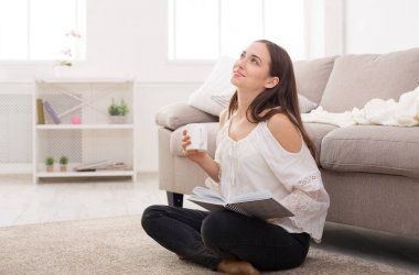 Genç kadın bir kitap üzerinde düşünme