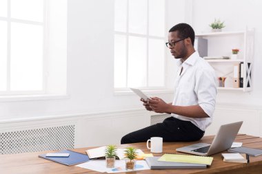 Modern ofis, konsantre siyah işadamı tablet ile çalışmak