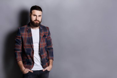 Sakallı yakışıklı elleri cebinde olan poz