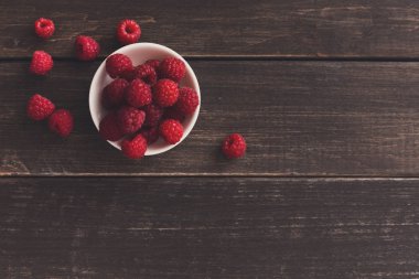 Kahverengi rustik ahşap arka plan üzerinde kırmızı taze frambuaz