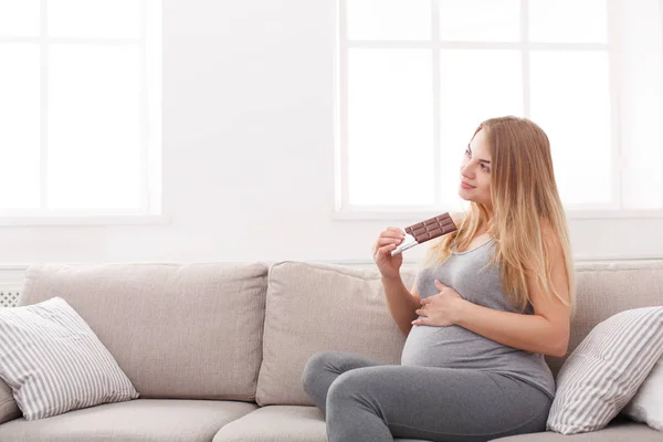 Mujer embarazada disfrutando de comer barra de chocolate — Foto de Stock