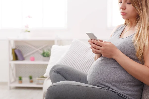 Zwangere jongedame met smartphone kopie space — Stockfoto