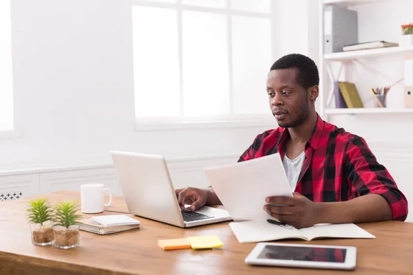 Uomo d'affari nero in ufficio casual, lavoro con laptop e documenti — Foto Stock