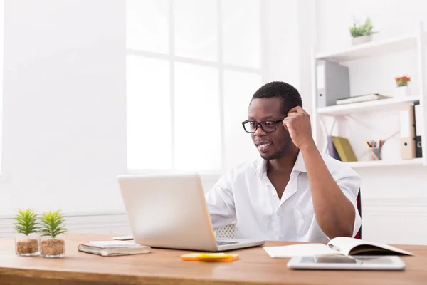 Feliz negro feliz hombre de negocios en la oficina, trabajar con el ordenador portátil, con gafas —  Fotos de Stock