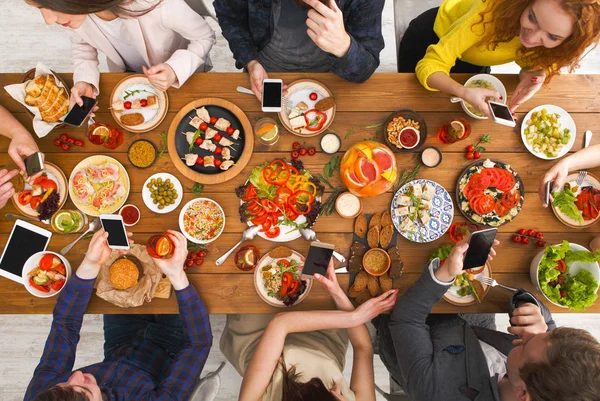 Gadget vício dispositivo, amigos jantar com smarphones — Fotografia de Stock