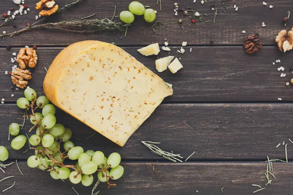 Käse-Hintergrund. Gouda mit Kräutern auf rustikalem Holz — Stockfoto