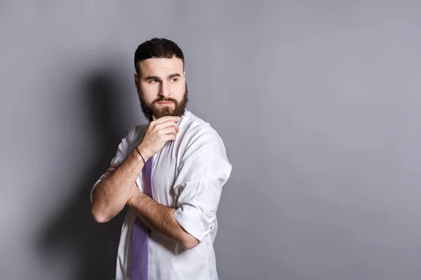 Nachdenklicher bärtiger Geschäftsmann mit der Hand am Kinn — Stockfoto